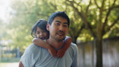 Un-Joven-Asiático-Feliz-Dando-Un-Paseo-Trasero-A-Su-Hija