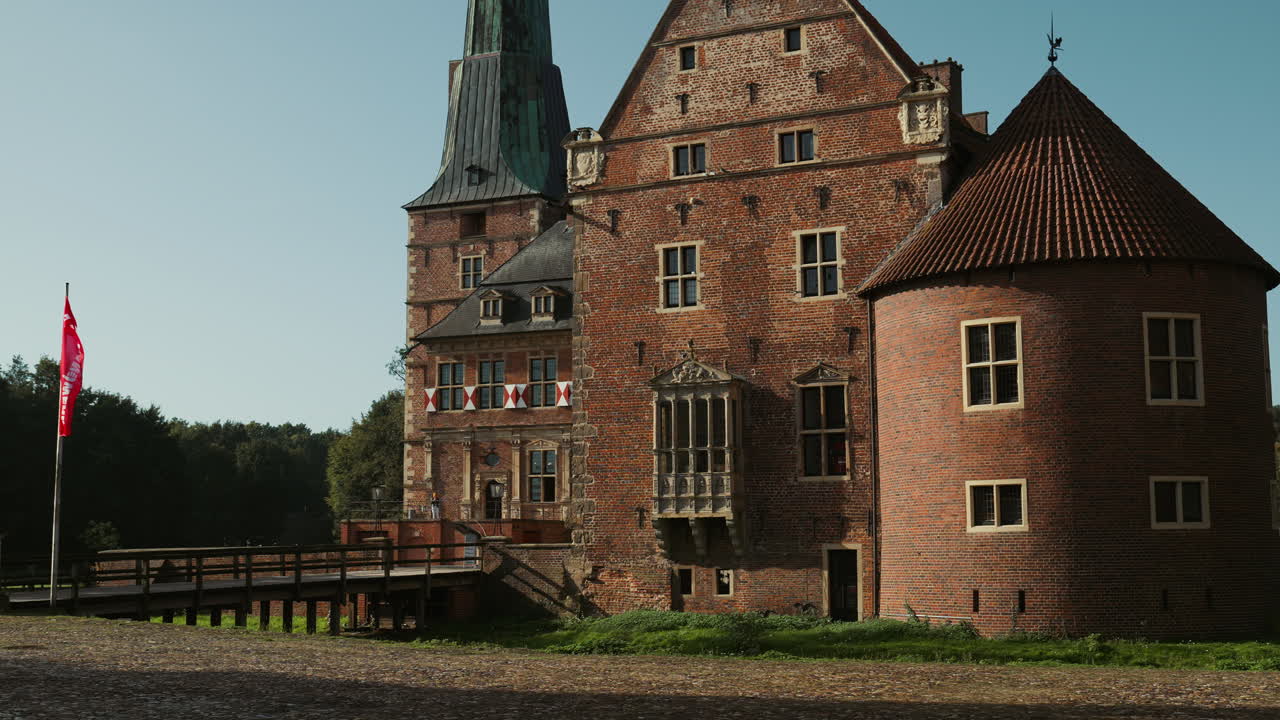 Schloss Raesfeld in Germany, surrounded by a calm pond and rich greenery. The medieval architecture stands out as a historic landmark in North Rhine-Westphalia