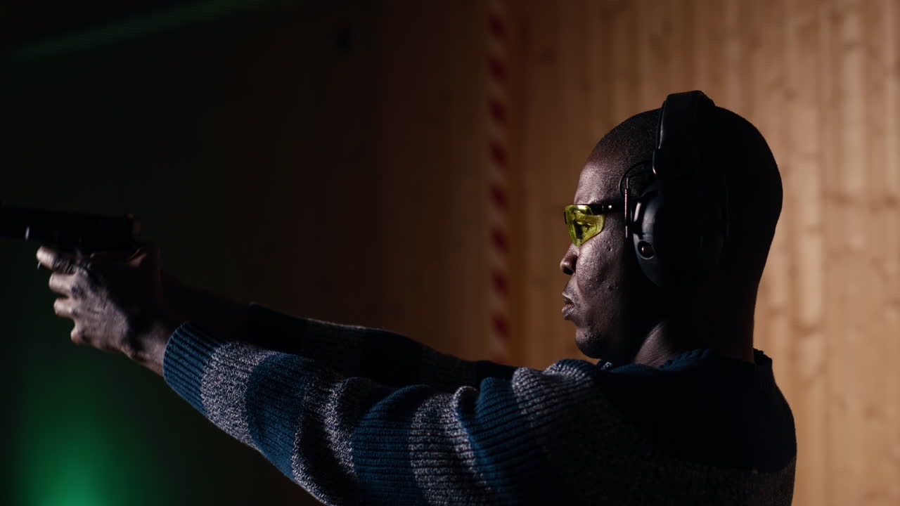 사격장에서 한 남자가 새로운 총 모델을 시험하고 구매를 약속합니다.