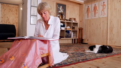 blonde lady reading a book while her sleeping dog keeps her company in her spiritual sanctuary