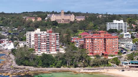 international college of management and seafront suburbs of manly in new south wales, australia. aerial pullback shot