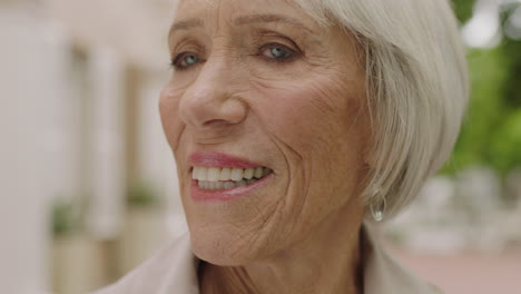 close up portrait of elegant elderly woman looking happy enjoying sightseeing in urban city background