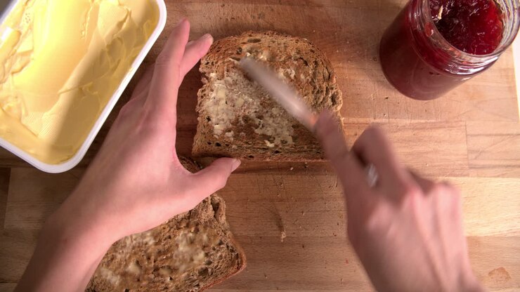 Point Of View Shot Showing Person Spreading Jam On Toast