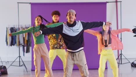 portrait of happy diverse male and female dancers dancing in dance studio, slow motion