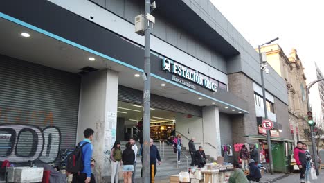 entrance of once station, train establishing shot with people walking by local neighborhood
