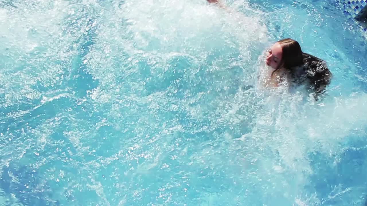 женщина плавает в бассейне.