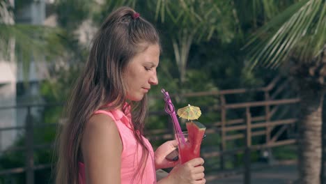 woman-with-berry-cocktail-in-hand-stands-on-hotel-territory