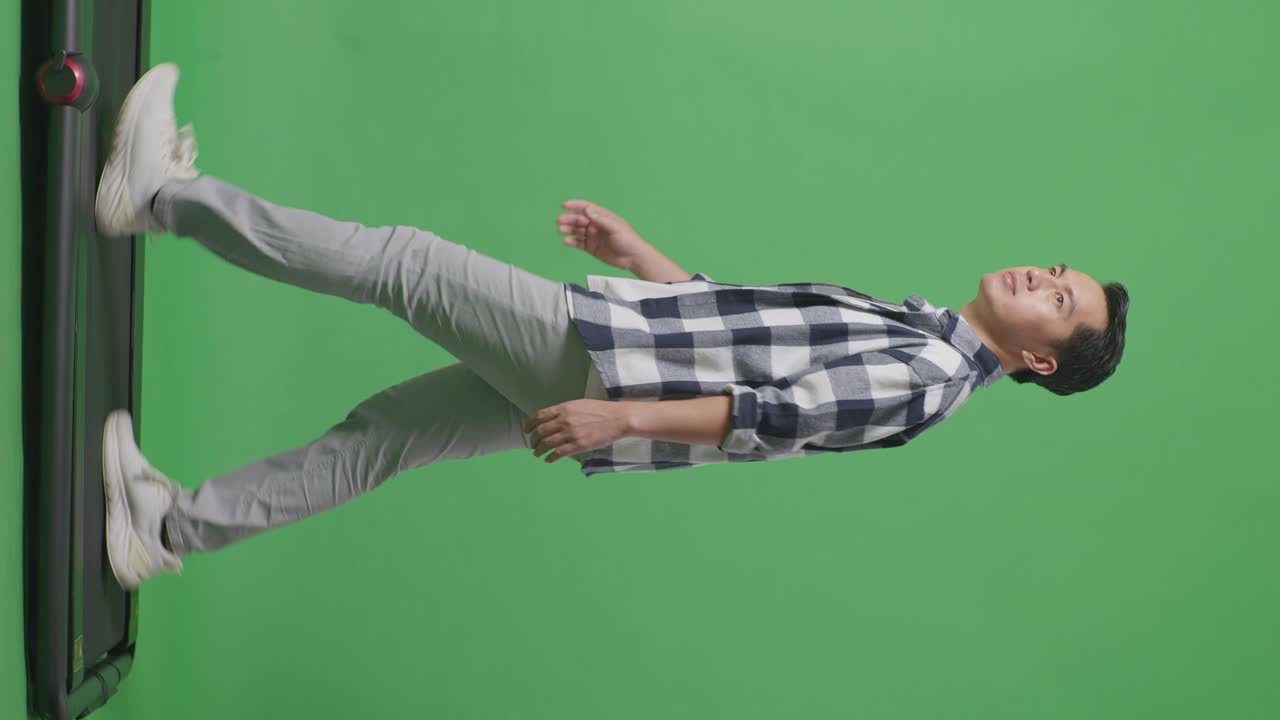 측면 뷰 아시아 남자의 전체 몸은 녹색 화면 배경에서 고 둘러보고 있습니다.