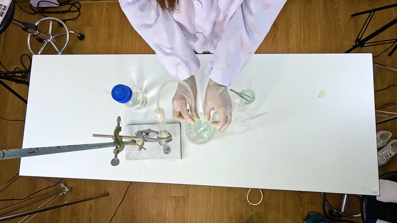 A scientist conducts a thermal decomposition experiment with copper carbonate on a laboratory table under controlled lighting