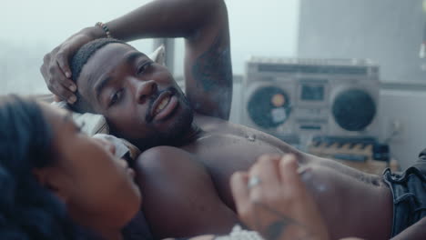 young couple smoking and chatting on bed