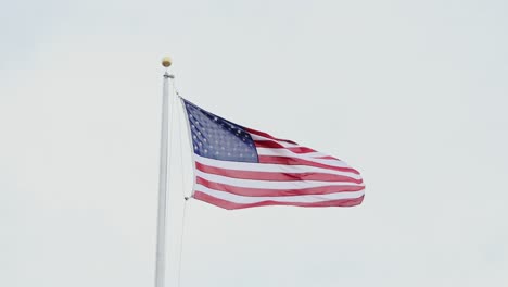 slow motion close-up, american waving flag, patriotism, freedom, white gray sky