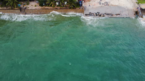 Stone-wall-protecting-coast-from-erosion-in-Phan-Thiet,-Vietnam,-aerial-top-down