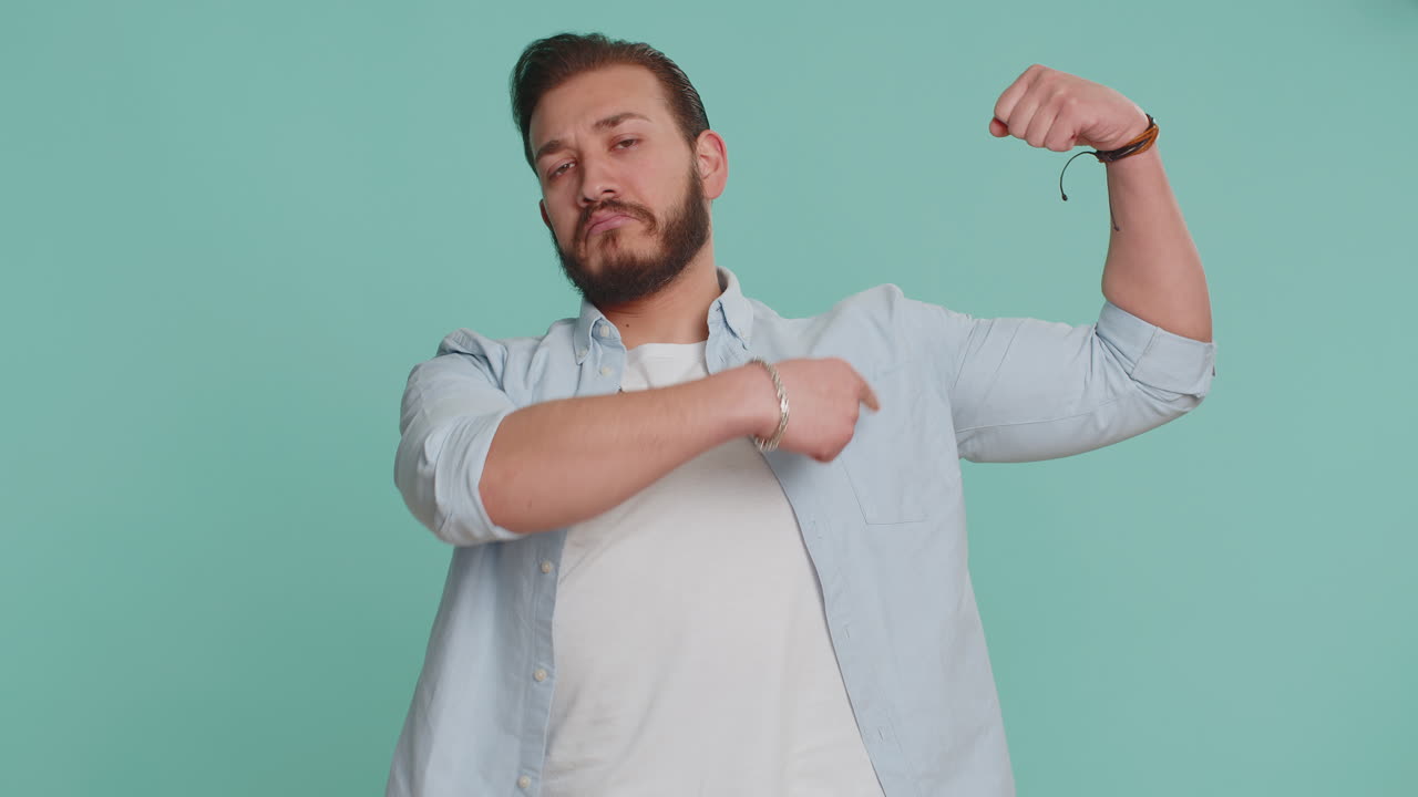 근육을 구부리고 자신감 있게 웃는 남자