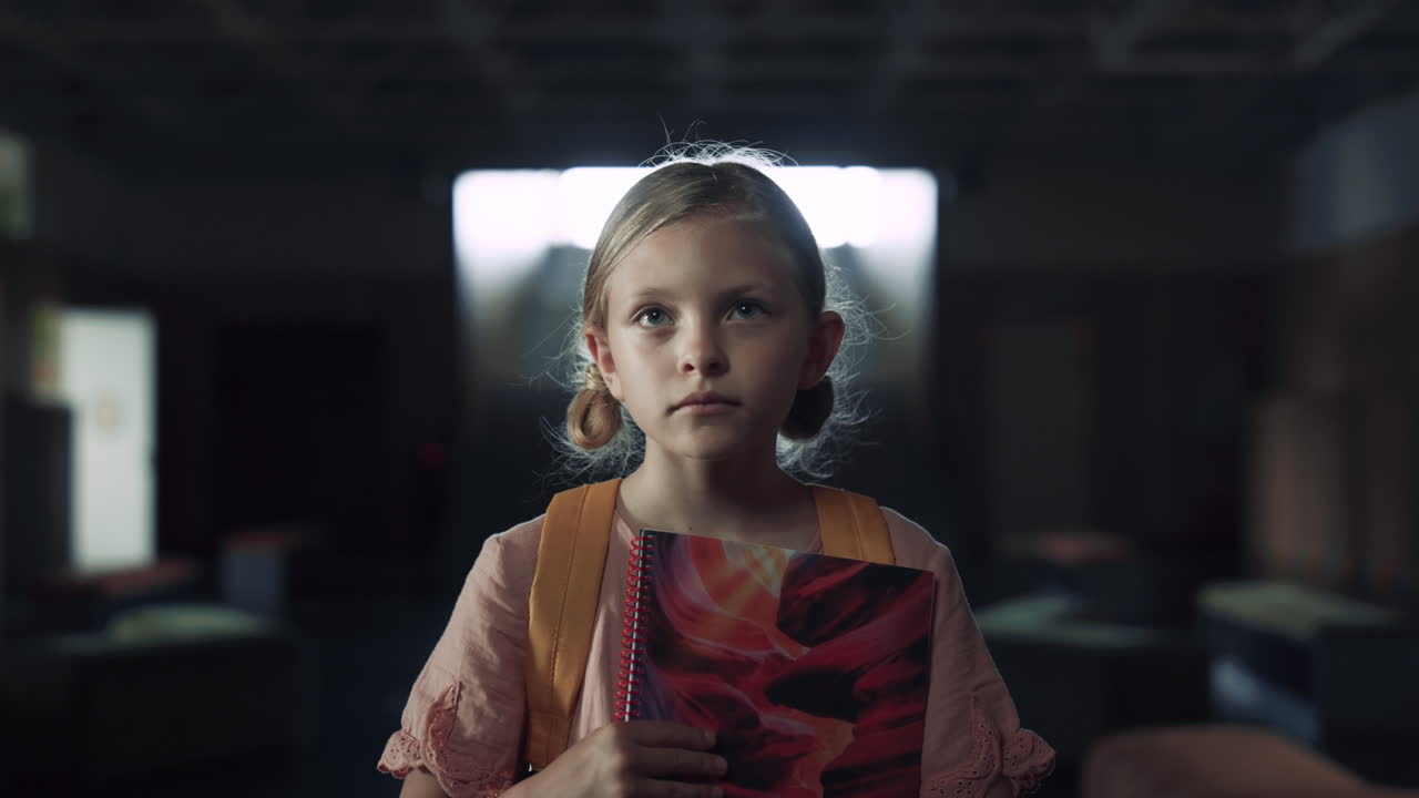 책을 들고 있는 여학생은 교실에 가까이 들어가기를 두려워합니다. 십대 아이가 서 있습니다.