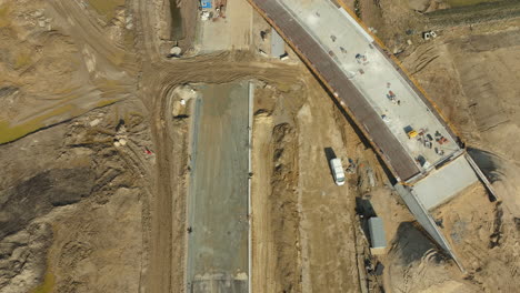 top-down view of road construction with an overpass and heavy machinery