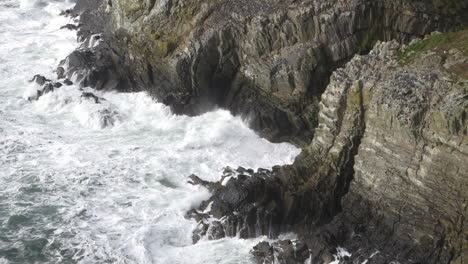 extreme slow motion puffin colony on rocks above stormy ocean