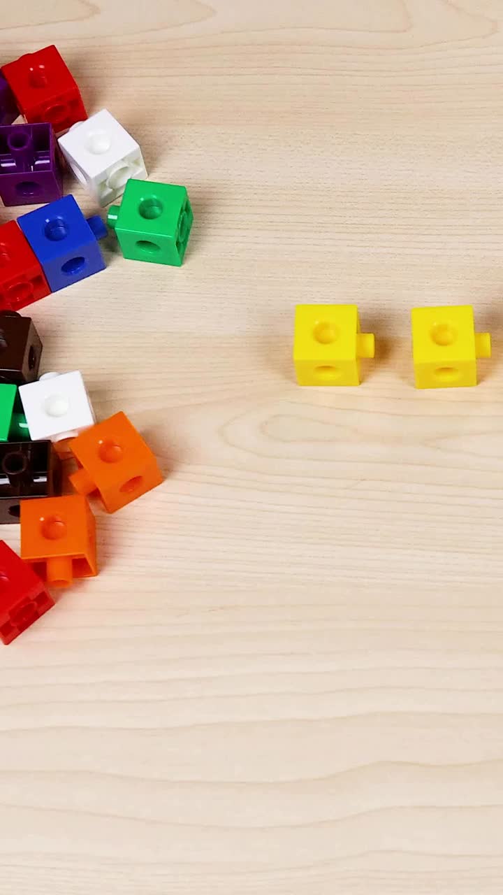 나무 테이블 에 큐브 를 조립 하는 손