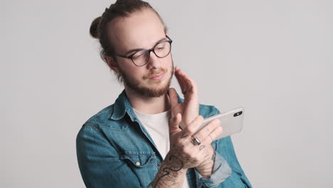 caucasian young man watching video on smartphone.