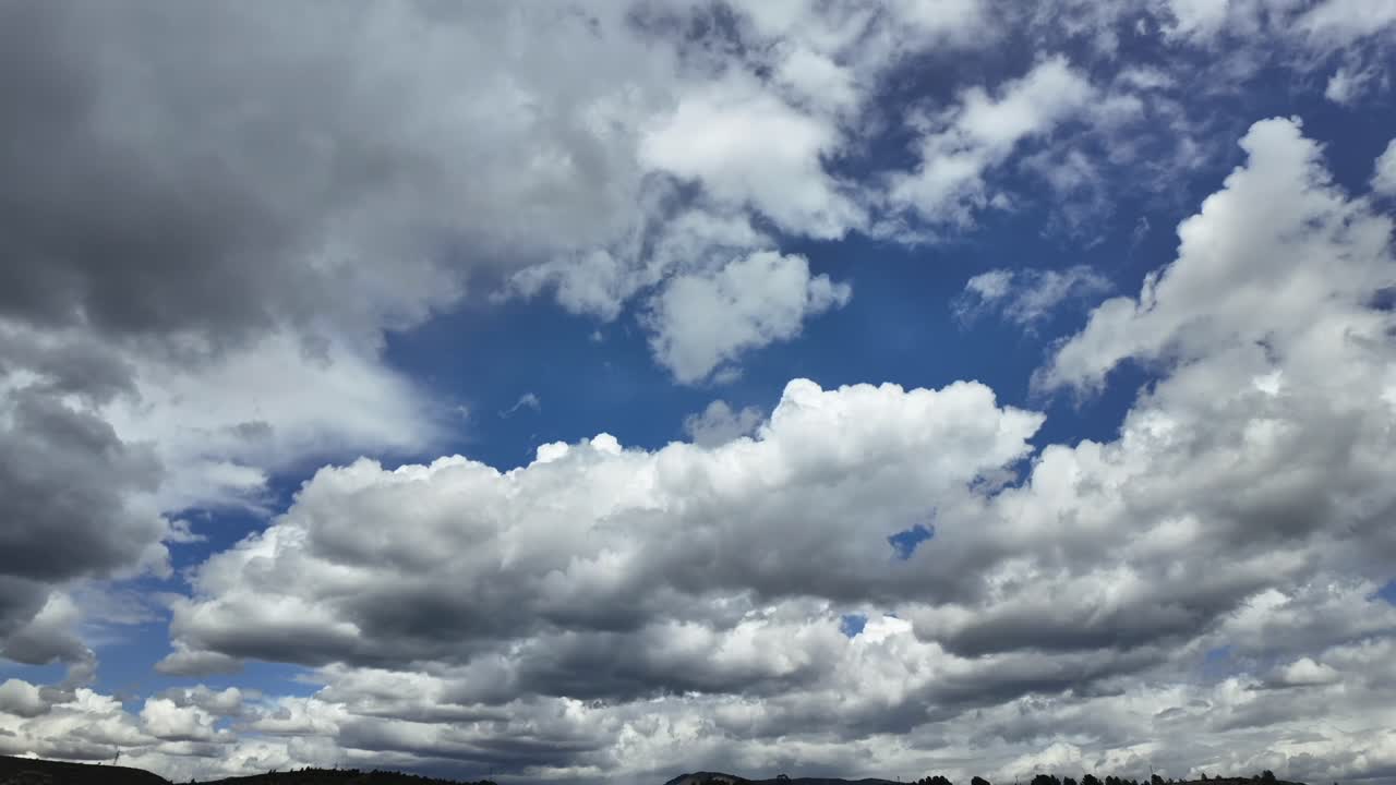 a timelapse of blue sky with evolving cottony clouds evolving into dark storm clouds.