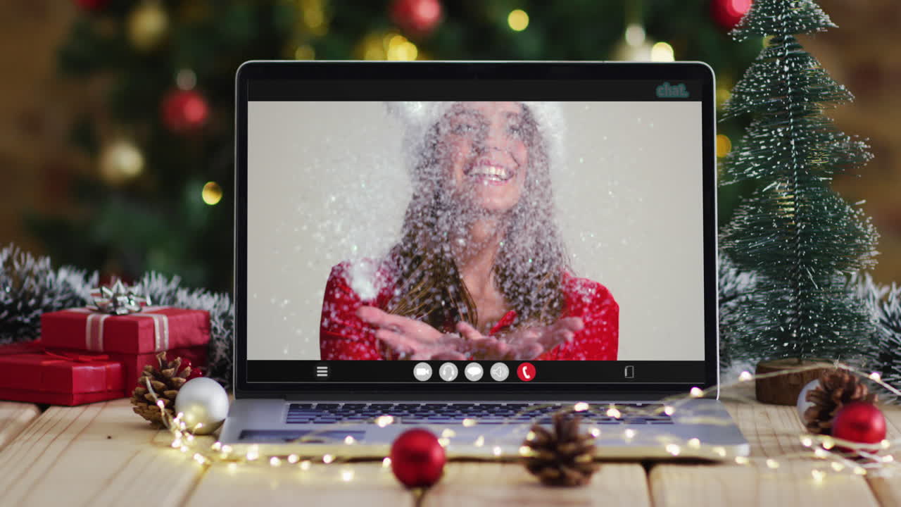 feliz mujer caucásica en disfraz de santa en videollamada en computadora portátil, con decoraciones de navidad y árbol
