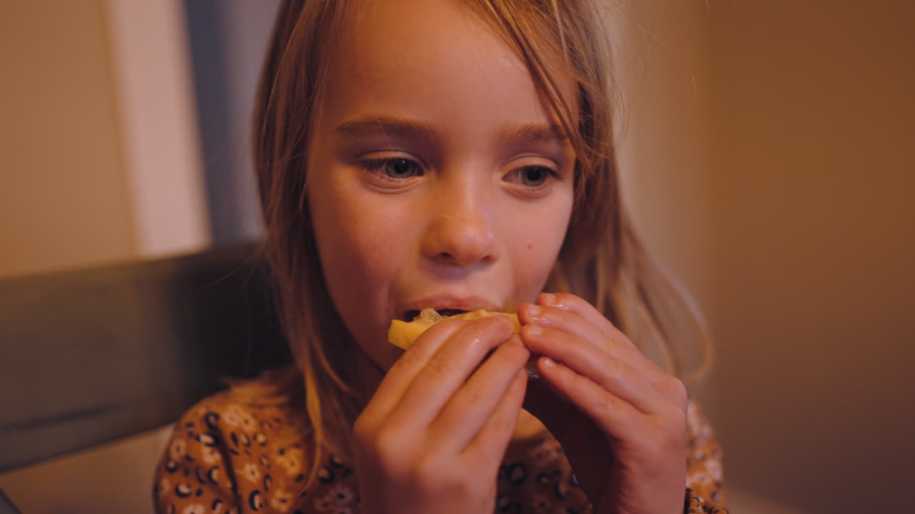 Little girl tastes a slice of sour lemon and reacts dramatically