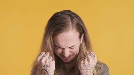 caucasian young man crossing fingers at the camera.