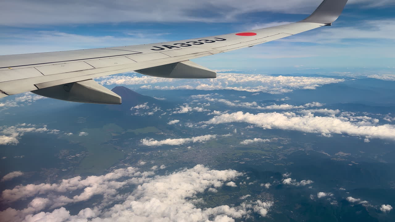 Japans Fuji-bjerg og det omkringliggende område set fra vinduet i et passagerfly
