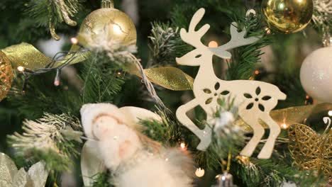 christmas tree with blinking lights and white gold ornaments. close up