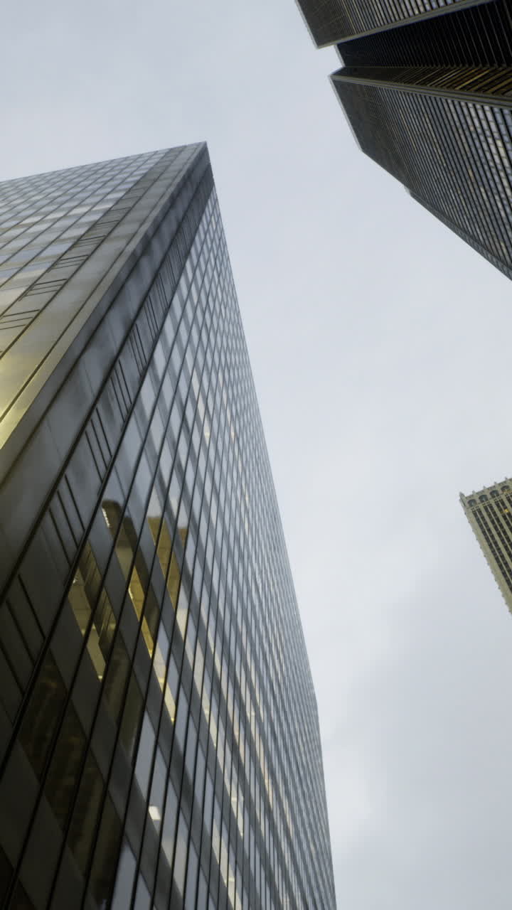 Edifícios altos refletem a luz sob um céu nublado em um ambiente urbano