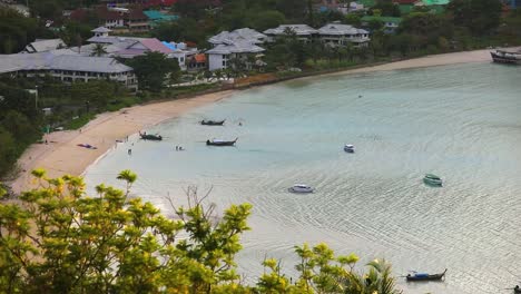 a scenic view of longtail boats along the beach of koh phi phi in thailand from a vantage point