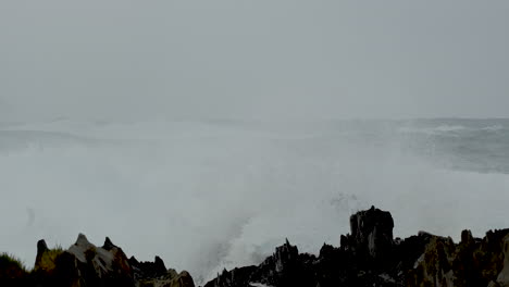 powerful wave crash over jagged rocks on coastline of storms river mouth. slomo