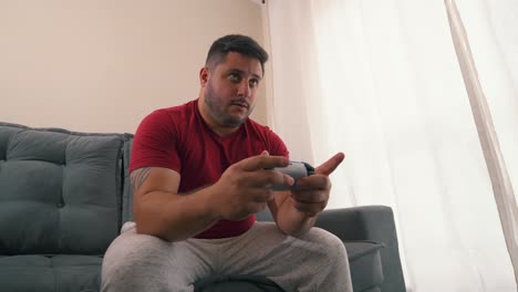 adulto joven centrado en jugar videojuegos con disparo de cámara lenta orbital de joystick