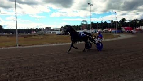A sulky driver practices his horse at the Cumberland Fair near Portland, Maine