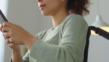 woman in wheelchair typing on mobile phone