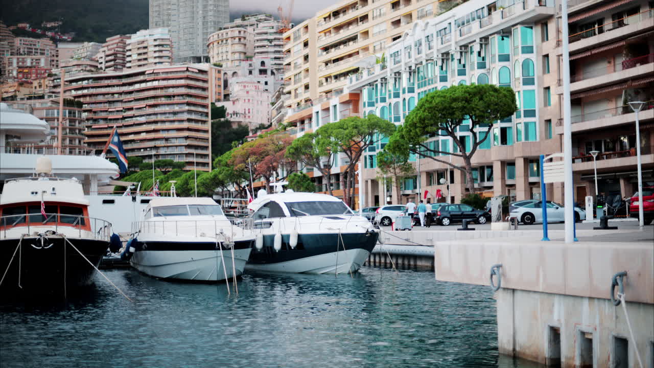 View of boats docked in the Monaco Marina with the skyline of the city on the background