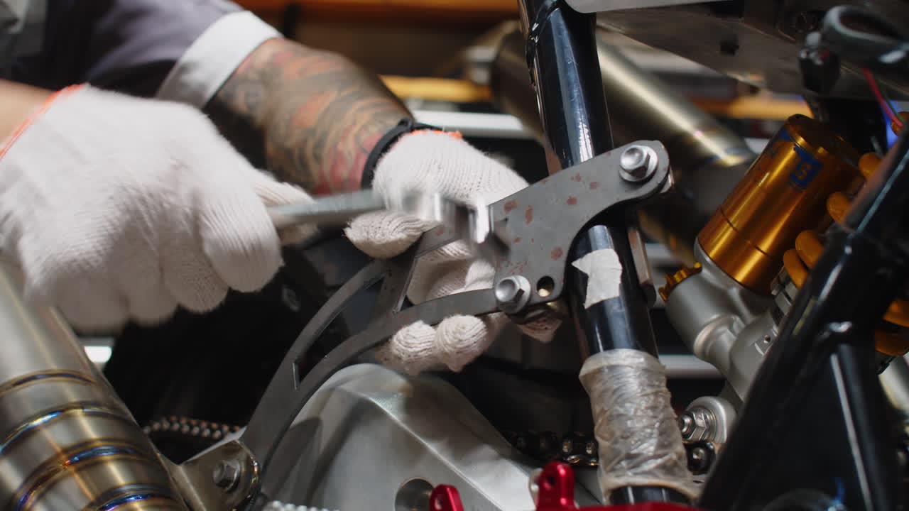 Hands of Mechanic Wrenching Detail of Motorcycle