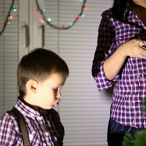 madre con su hijo decorando el árbol de navidad