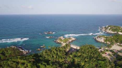 Agua-Del-Océano-Rompiendo-En-Calas-Escondidas-En-El-Parque-Nacional-Tayrona,-Colombia,-Retroceso-Aéreo