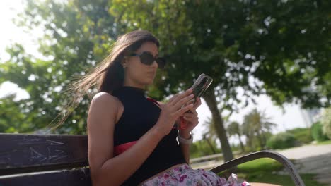 woman texting on smartphone in park