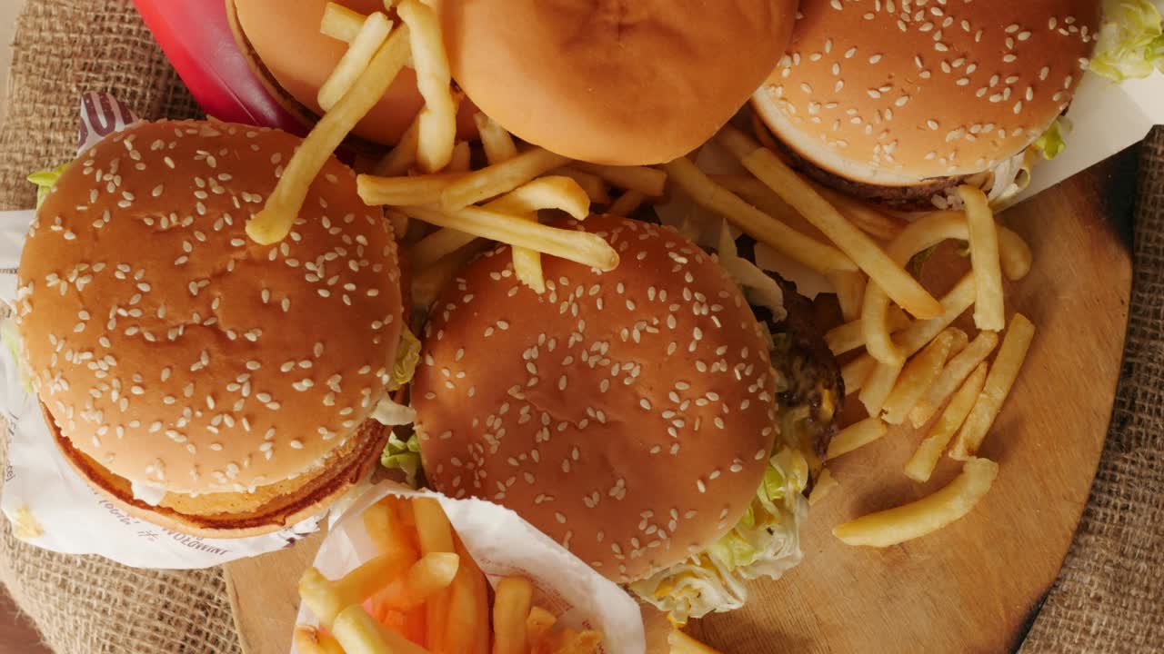 porción de comida no saludable, comida rápida, pila de hamburguesas, patatas fritas girando, girando