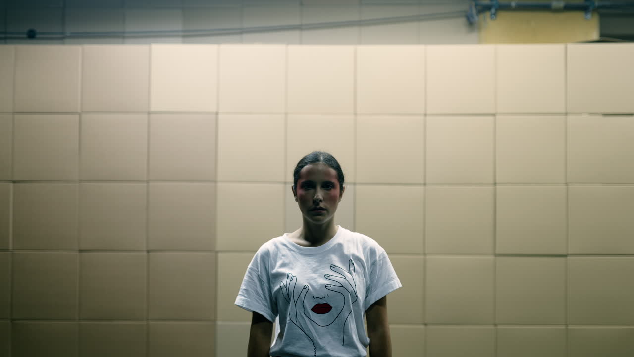 Teenage girl portrait with artistic makeup and graphic t-shirt in front of tiled wall