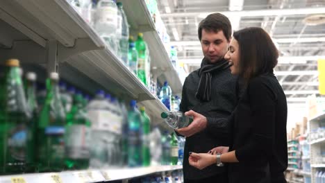 couple shopping for water bottles in a grocery store