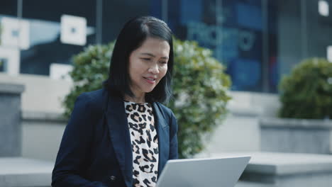 businesswoman working on laptop outdoors