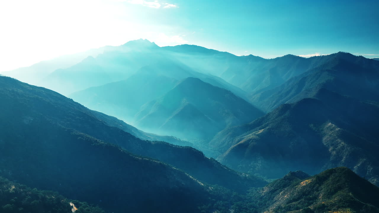 Beautiful mountains covered with greenery in the rays of bright sun. Gorgeous rocks in the blue light.