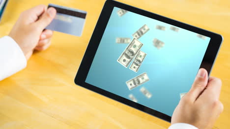 tableta que muestra el video de billetes de dólar lloviendo