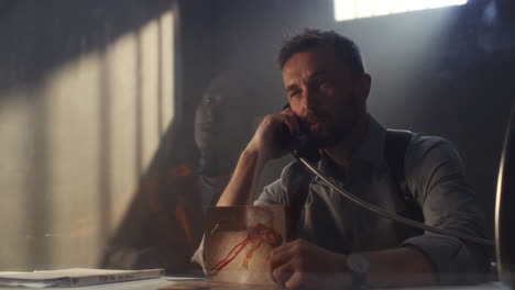 detective presenting photo of victim during interrogation in prison