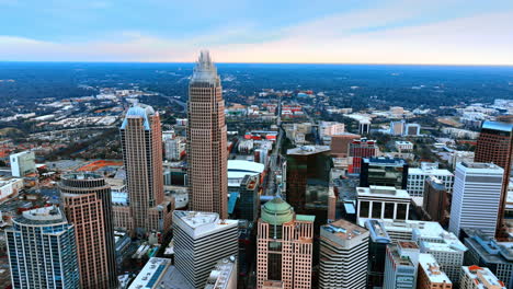 drone approaching the group of high-rise buildings built close to each other in the city downtown. view of north carolina, usa from aerial perspective