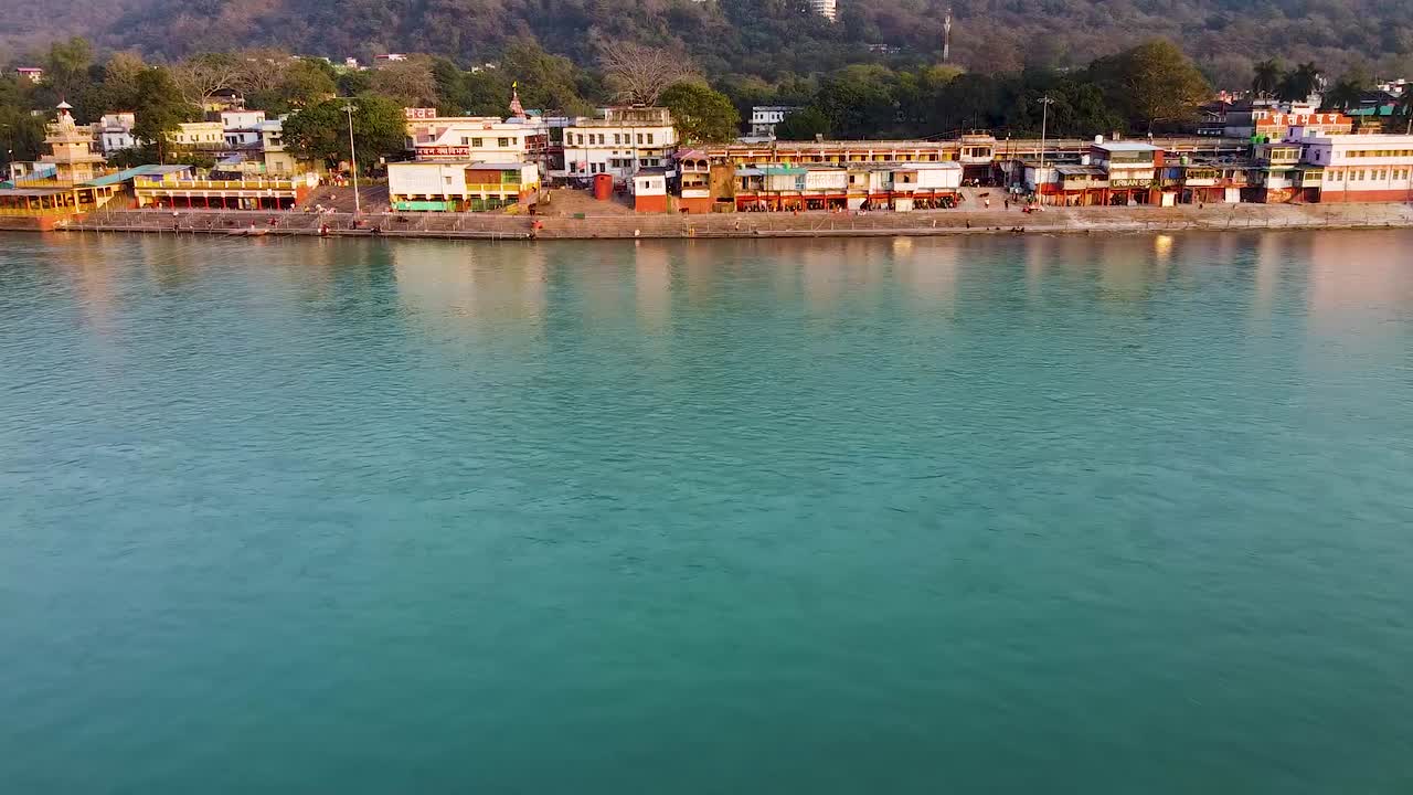 la orilla del río sagrado ganges llena de templos religiosos al atardecer se toma un video aéreo en rishikesh uttrakhand india el 15 de marzo de 2022