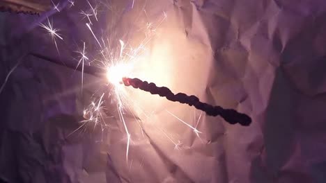 primer plano de la luz de fuegos artificiales bengala y un fondo de papel rayado