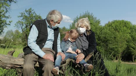 Abuelos-Con-Nieta-Con-Máscaras-Médicas-En-El-Parque.-Cuarentena-Por-Coronavirus